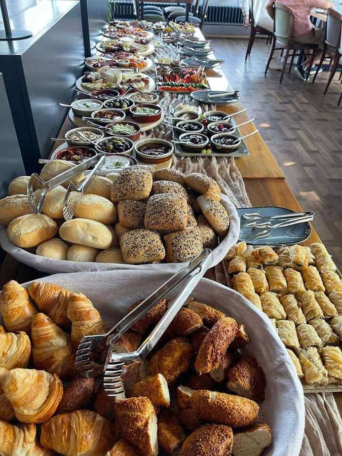 Reich gedeckte Brunch-Tafel mit Brot, Börek, Aufstrichen und Obst